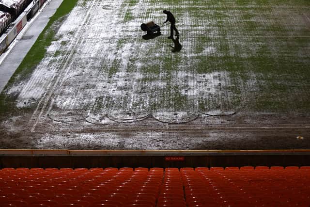 A member of ground staff attempts to roll the pitch at Valley Parade. (Photo by George Wood/Getty Images)