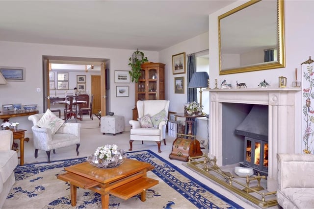 The 27ft triple-aspect drawing room is wonderfully bright with a feature fireplace, log-burner and door to the garden
