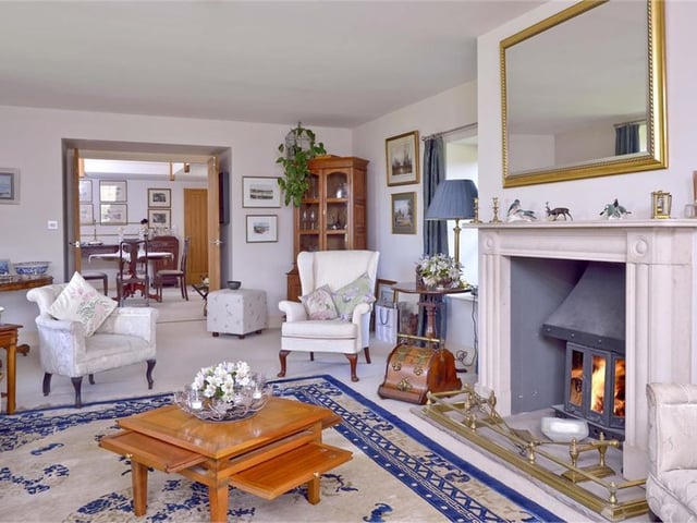The 27ft triple-aspect drawing room is wonderfully bright with a feature fireplace, log-burner and door to the garden