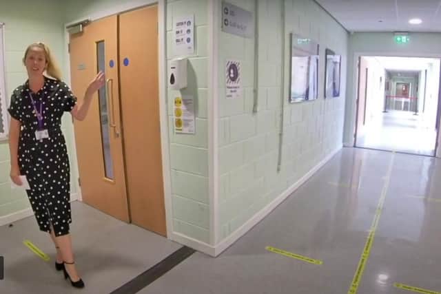 Outwood Academy Adwick assistant principal Hannah Smith shows the yellow lines to help keep pupils 2m apart, and a hand sanitiser outside a classroom
