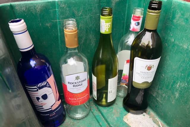 Empty wine bottles in a recycling bin.
