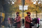 A woman is reflected in a window as she leaves a shop in central Sheffield (Photo by OLI SCARFF/AFP via Getty Images)