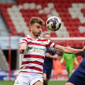 Doncaster's George Miller battles with Wimbledon's Alex Pearce.