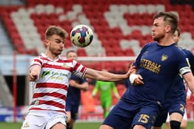 Doncaster's George Miller battles with Wimbledon's Alex Pearce.