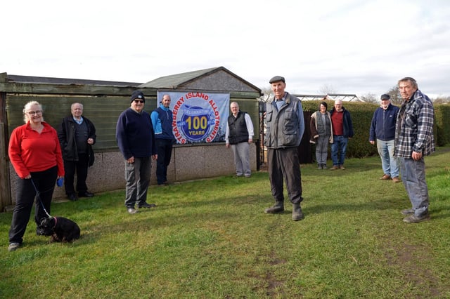 Celebrating 100 years of Strawberry Island Allotments are l-r Marie Jeeves and Tilly, Tony Mulhall, Robin Story, Vice Chairman of the SIAA, Carl Probert, Bob Peace, Charlie Bennett, Chairman of the Strawberry Island Allotments Association, Sandra and Andy Faulkner, Russ Haywood and John Hill. NDFP-09-03-21-StrawberryIsland 2-NMSY