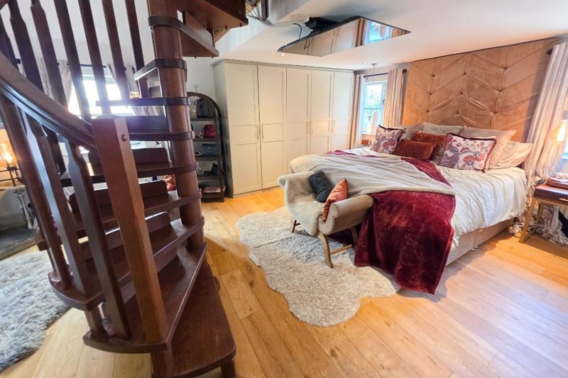 The main bedroom on the ground floor has a feature spiral staircase leading up to a handy mezzanine level.