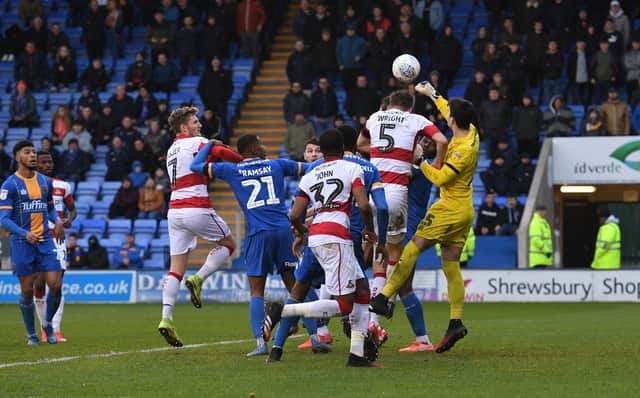 Doncaster Rovers defender Joe Wright puts Shrewsbury Town 'keeper Max O'Leary under pressure at the New Meadow. Photo: Howard Roe/AHPIX LTD.
