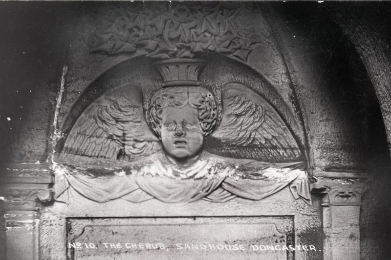 A carving of a cherub in the tunnel known as the Cloisters.