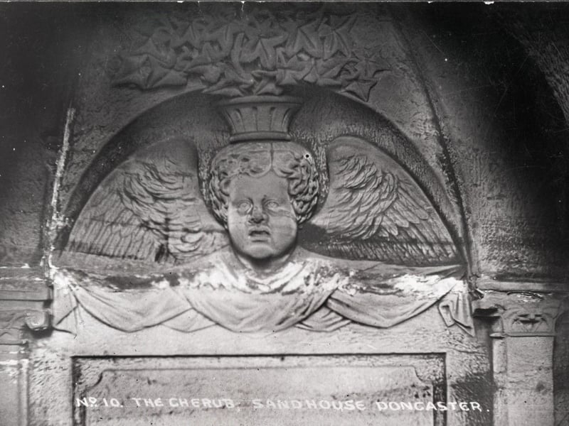 A carving of a cherub in the tunnel known as the Cloisters.