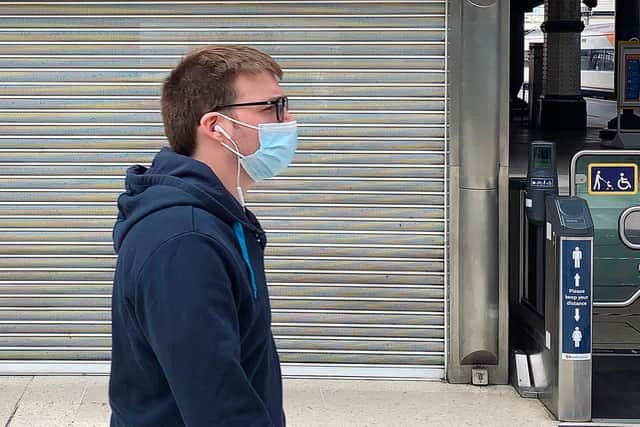 A pedestrian wearing PPE (personal protective equipment), of a face mask or covering as a precautionary measure against spreading COVID-19.(Photo by DANIEL LEAL-OLIVAS/AFP via Getty Images)