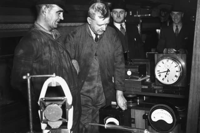 3rd June 1938:  Fireman T H Bray  on the left and next to him Driver R J Duddington who made history by driving the LNER locomotive 'Mallard' at 125mph. They are in the dynamometer car at Kings Cross station, London studying the instruments which recorded the record-breaking feat.  (Photo by Fox Photos/Getty Images)