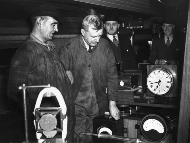 3rd June 1938:  Fireman T H Bray  on the left and next to him Driver R J Duddington who made history by driving the LNER locomotive 'Mallard' at 125mph. They are in the dynamometer car at Kings Cross station, London studying the instruments which recorded the record-breaking feat.  (Photo by Fox Photos/Getty Images)