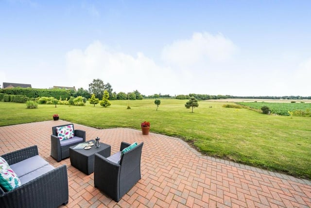 Patio seating with views over the property's own gardens and land, and countryside beyond.