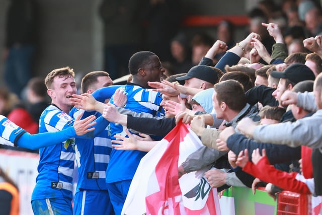 Doncaster Rovers' Maxime Biamou is buried under players and fans as he sealed the three points late on at Crawley.