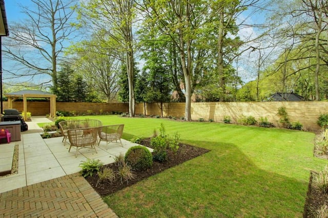 Tranquil gardens with seating areas and a backdrop of trees.