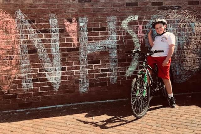 Jude Dickinson shows the wall decorated in support of the NHS