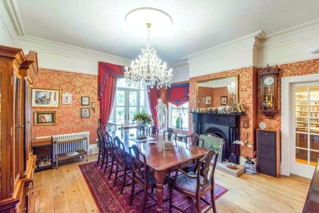 A dining room with feature fireplace has doors out to the garden.