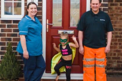 Keyworker parents with their daughter dressed as a super hero.