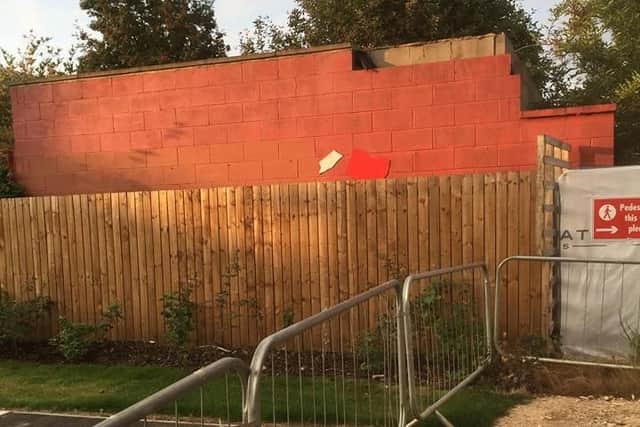A red perimeter wall from the old Belle Vue.