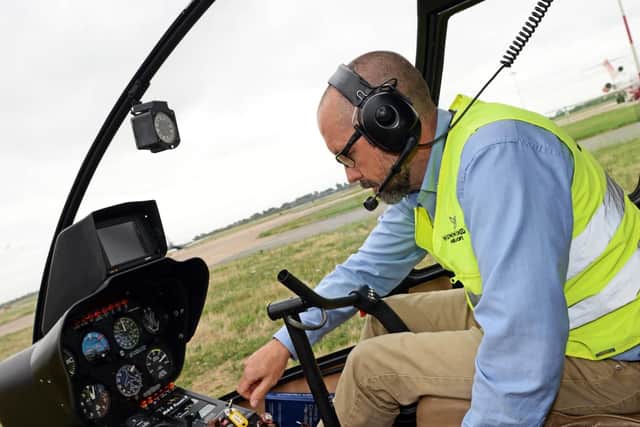 Capt. Matthew M Rake, of Hummingbird Helicopters, pictured at the controls of his four seater Robinson R44. Picture: Marie Caley NDFP-04-09-18-Hummingbird-6