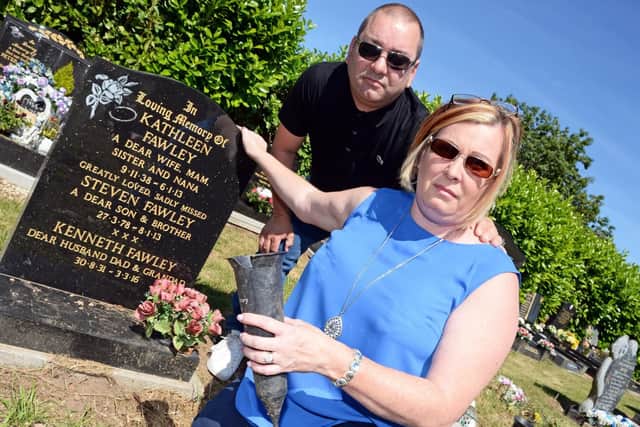 Michelle Cook and her husband Paul, pictured beside the grave of her parents and her brother at Redhouse Cemetery. Picture: Marie Caley NDFP Cook MC 2