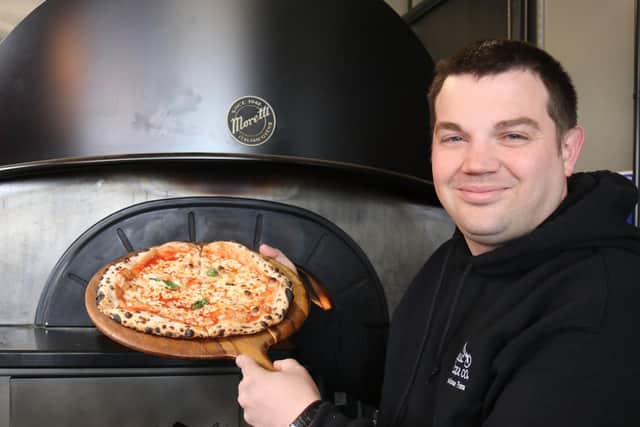 Lee Oglen, Owner with pizza.