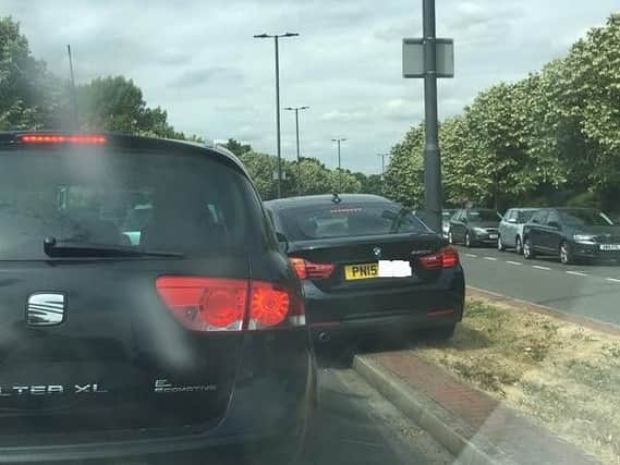 The BMW was spotted using the grass verge to avoid waiting in a traffic jam.
