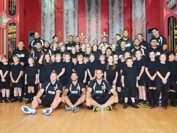 Children from Norton Junior school pictured with members of the New Zealand rugby team after watching them perform the Haka. Picture: Marie Caley D5639MC