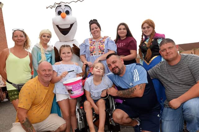 Myla Mae Carte, pictured with her parents Trev, Lyndsey, sisters Madi, 14, and Macie, eight, event organisers Traci Kowalski, Steve Lock, Darren Simpson and entertainers from Precious Memory's at Skellow Grange Social Club, during the fundraising event. Picture: Marie Caley NDFP-18-08-18-MylaFundraiser-1