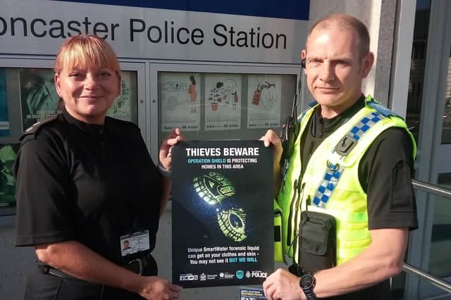 Insp Lynne Lancaster and PCSO Roy Turton, local officer for Balby, with a poster for Operation Shield