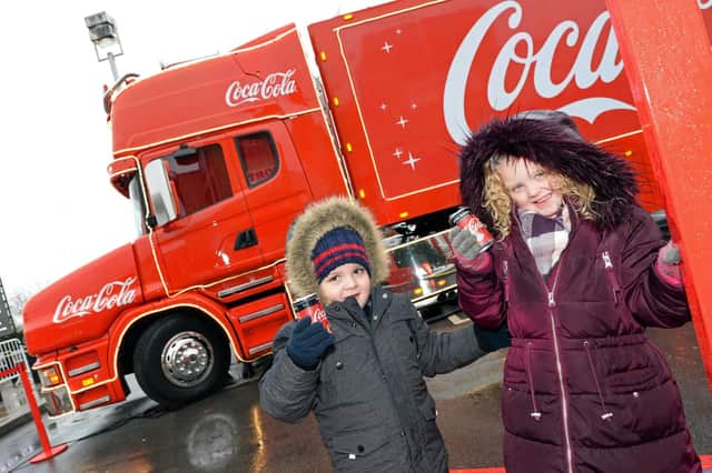 Arlow Tidmarsh-Sawicki, three, pictured with Lilly Tidmarsh, five, of Kirk Sandall pictured visiting the Coca Cola truck at Lakeside yesterday. Picture: Marie Caley