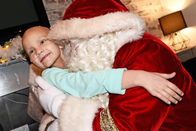 Myla Carte, five, gives Santa a hug, after surprising her with a visit to her home. Picture: NDFP-18-12-18-CarteSanta-3