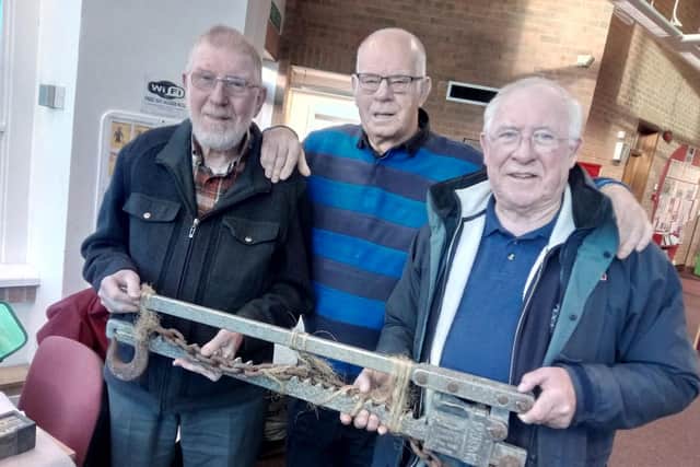 Former Brodsworth miners Bob Colville, aged  87, Dave Alvin, aged 76, and Dave Gilling, aged 75 with a lever and ratchet used for pulling pit props underground.