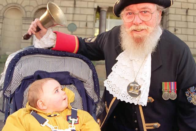 Doncaster's Town Crier Ted Corney rings in the New Year watched by Balby youngster Arron Robson, aged ten months.