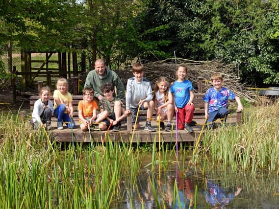 Nigel Senior, general manager, pictured with children taking part in Pond Dipping at Austerfield Study Centre, during Holiday Club. Picture: Marie Caley NDFP-23-04-19-Austerfield-1