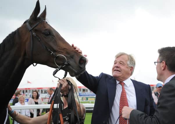 SIR MICHAEL STOUTE (centre), who trains today's Tip Of The Day (PHOTO BY: Anna Gowthorpe/PA Wire).