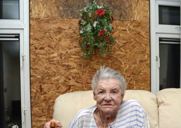 June Green, pictured by her window that was smashed by a breeze block. Picture: Marie Caley