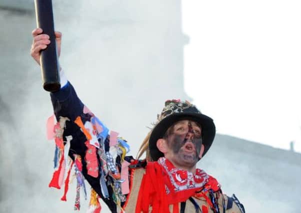 The Fool Dale Smith holds the hood high at the Haxey Hood. Picture: Andrew Roe