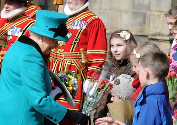 The Queen collects flowers from children outside Sheffield Cathedral for Maundy Thursday. Picture: Andrew Roe