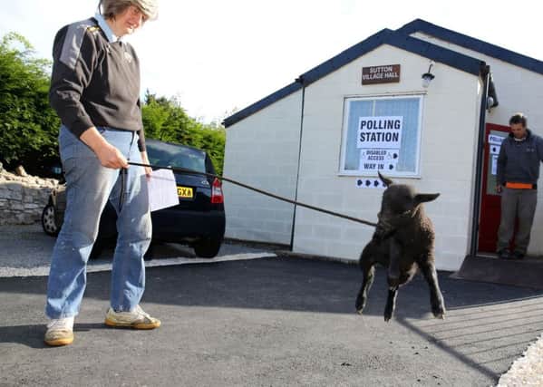 Judith Preston walks her pet lamb Beth as she attends Sutton village hall in Doncaster to cast her vote