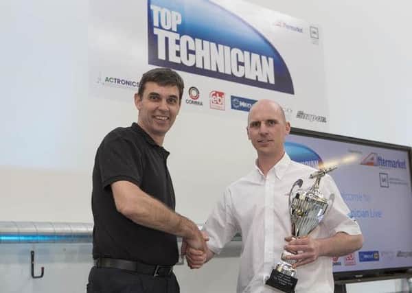 Andrew Gravel, right, is handed his trophy by Ian Gillgrass, head of the IMI motor vehicle training institute.