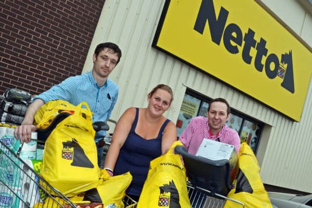 Lindsay Harris, of Conisbrough, pictured with store managers Frank Andersen and Chris Elsey, outside the store with the items she collected during the trolley dash. Picture: Marie Caley NDFP Netto Dash MC 19