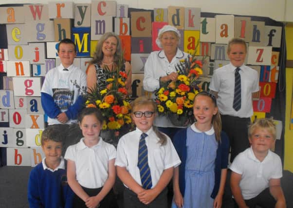 Val Cumbor, school cook is retiring after 19 years on the right and Sue Kirk, Teaching Assistant retiring after 20 years, on the left with several children at Auckley School.