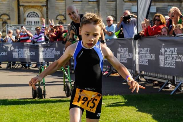Bailey Matthews 8 from Doncaster crosses the finish line to complete his first ever triathlon at Castle Howard on sat.