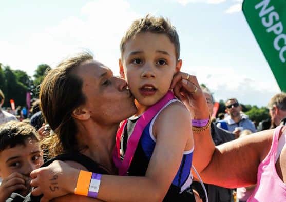 Bailey Matthews 8 from Doncaster gets a kiss from his mother Julia after he crossed the finish line to complete his first ever triathlon at Castle Howard on sat.