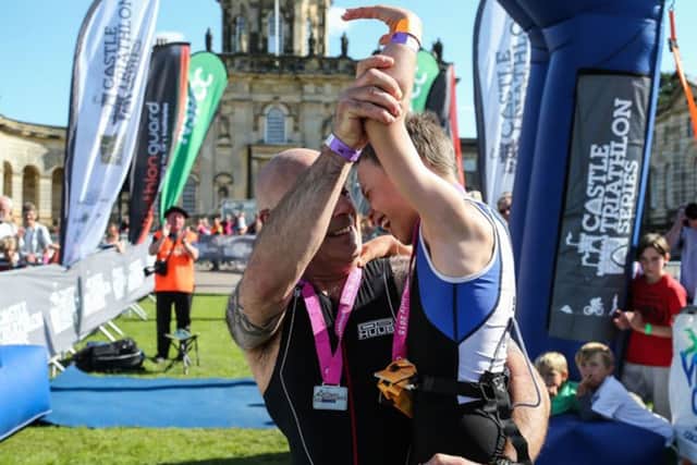 Bailey Matthews 8 from Doncaster is congratulated by his Dad Jonathan after crossing the finish line to complete his first ever triathlon at Castle Howard on sat.