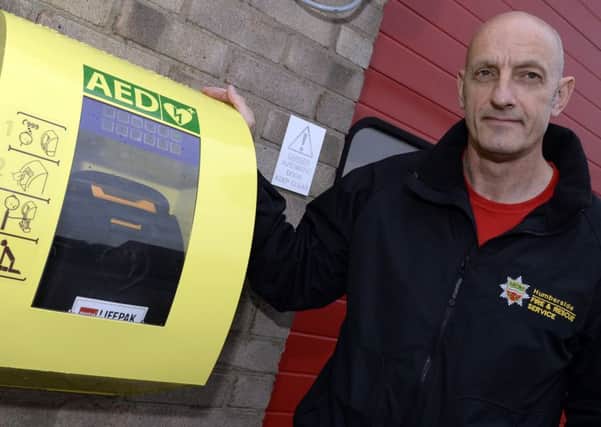 John Armson from Humberside Fire and Rescue by the new defibrillator that has been installed at Crowle Fire Station