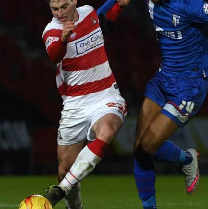 Doncaster's Conor Grant battles with Gillingham's Dominic Samuel