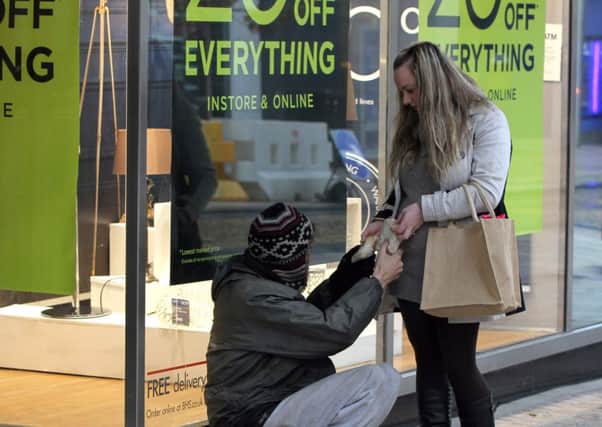 A woman handing out food to a homeless man