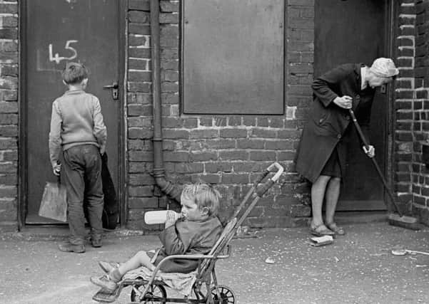 Mrs Tandy cleaning her backyard, Sheffield 1969 36-10.  Image taken by Nick Hedges for homeless charity Shelter.